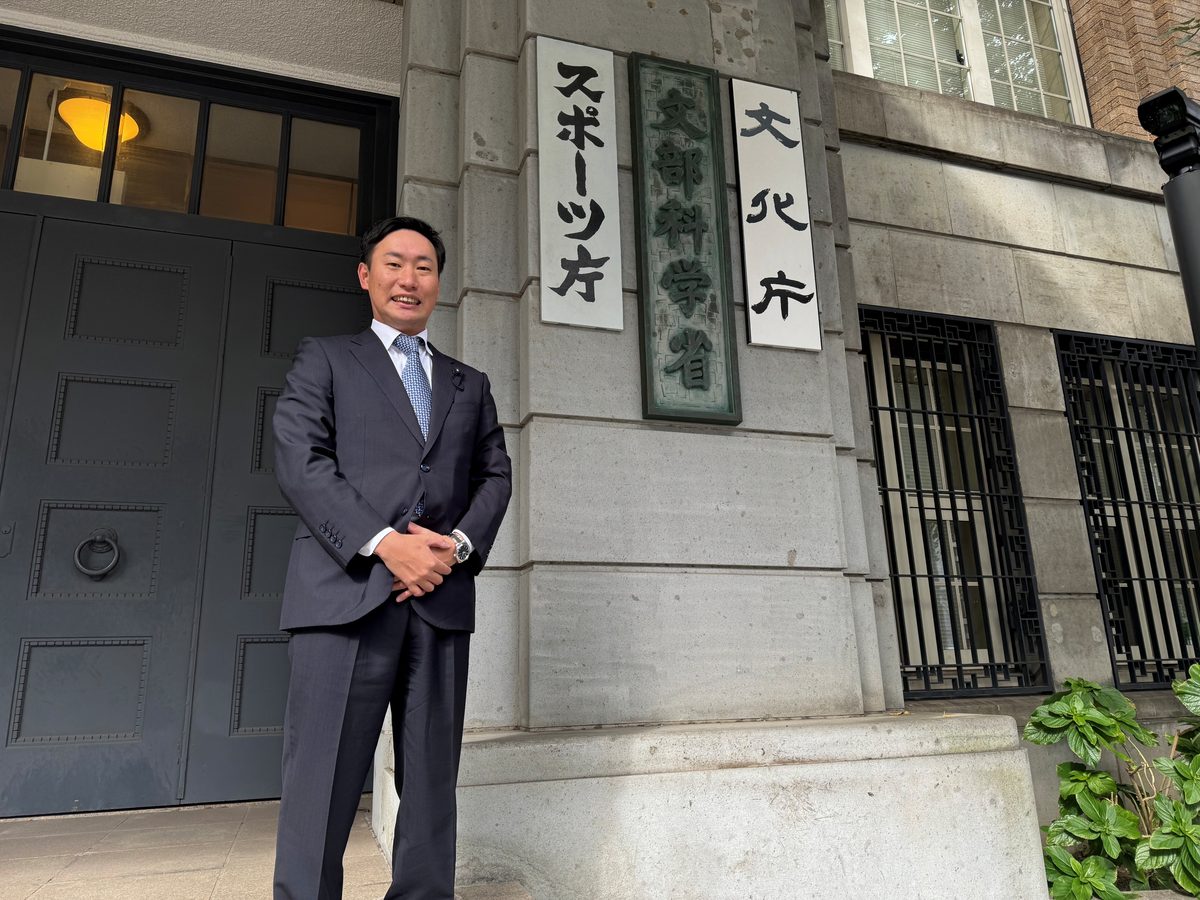 文化庁・スポーツ庁の前に立つ川口信